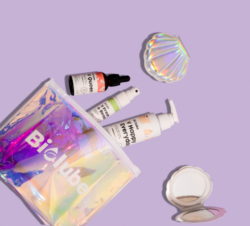 Biolouve travel kit products arranged on lavender background with mirror and holographic pouch
