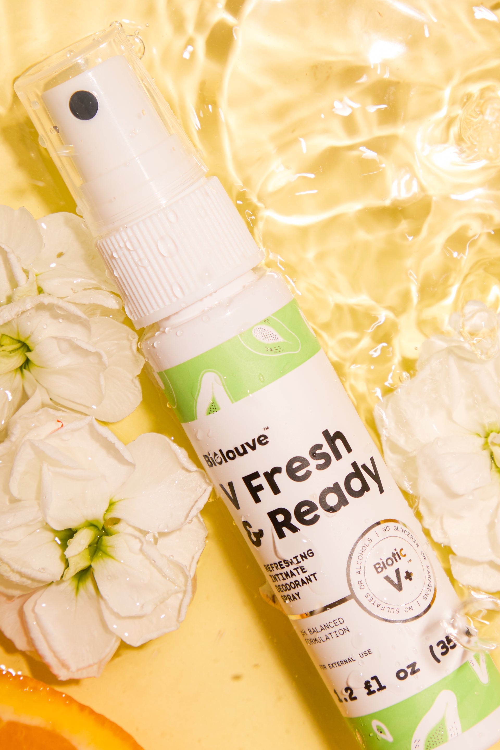 Biolouve V Fresh and Ready intimate mist bottle submerged in golden water with white flowers representing daily freshness routine