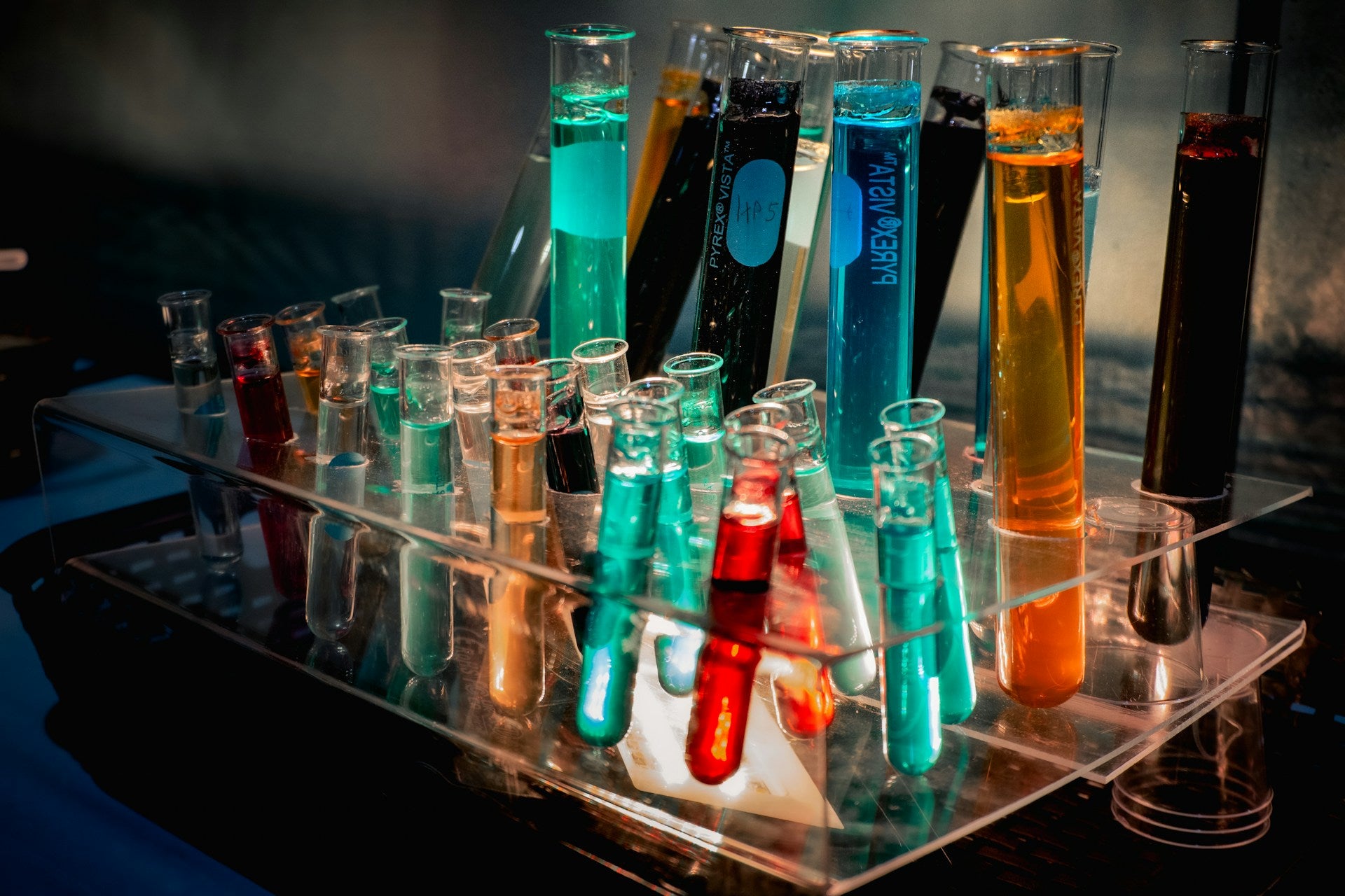 Collection of test tubes with colorful liquids on a stand representing postbiotic biotechnology research