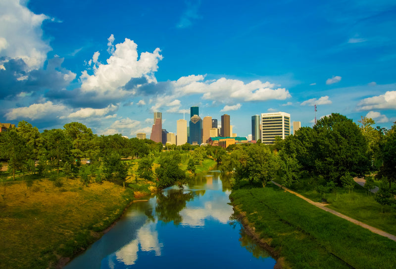 Buffalo Bayou Park with Houston skyline and green trees reflected in water