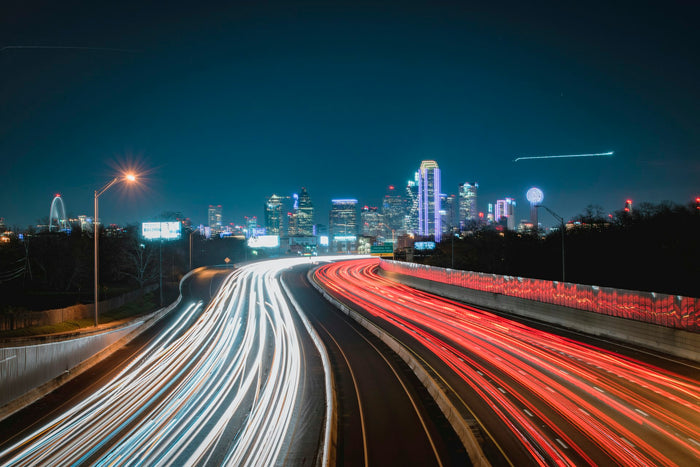 Texas highway leading to Dallas skyline at sunset